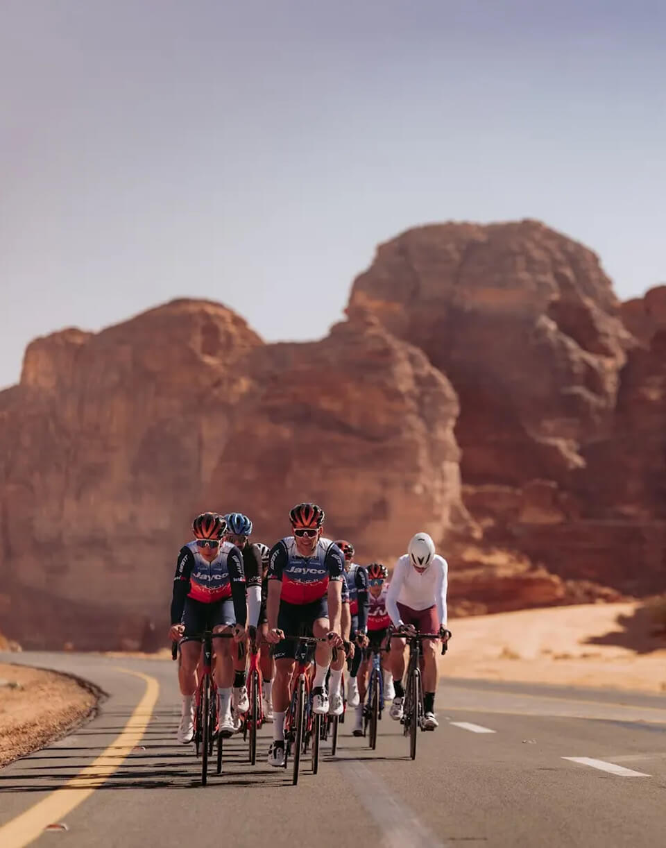 Peloton de cyclistes sur une route d'AlUla