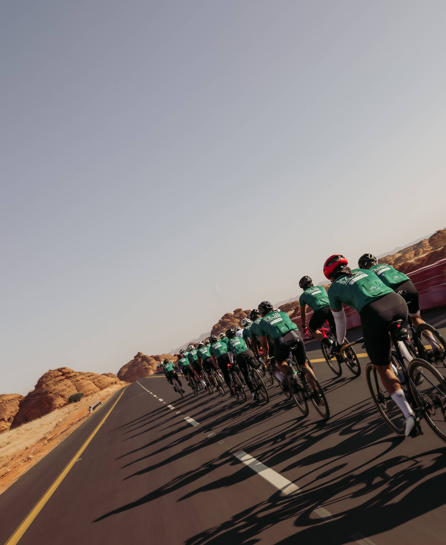Peloton de cyclistes sur une route d'AlUla
